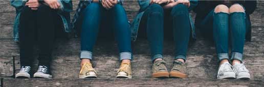 children sitting on steps, image cropped from knees down